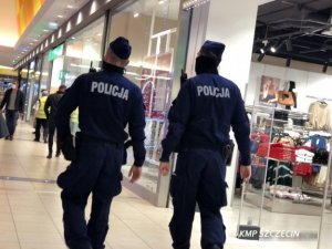 dwóch policjantów w galerii handlowej dokonujących kontroli obiektu w związku z obostrzeniami Covid 19