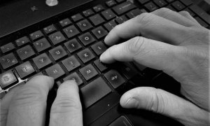 czarno-biały obrazek pokazujący dłonie osoby piszącej na klawiaturze od komputera