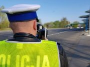 policjant ruchu drogowego dokonujący pomiaru ręcznym miernikiem prędkości